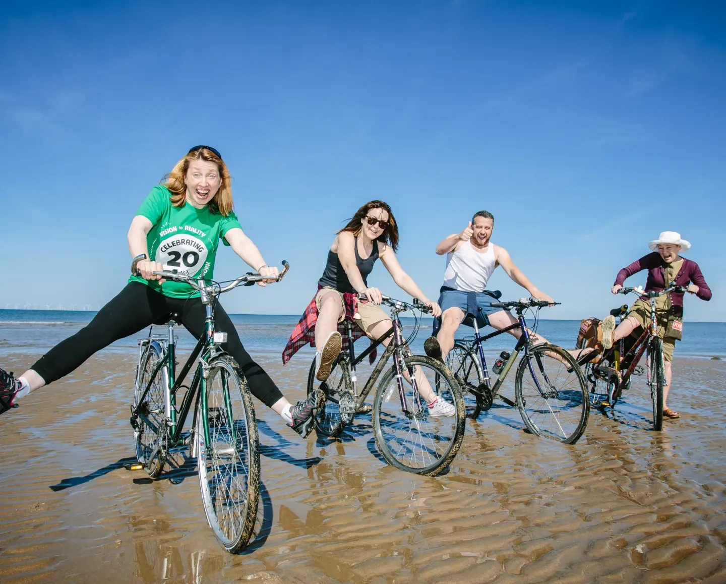 Four people on bikes on the beach
